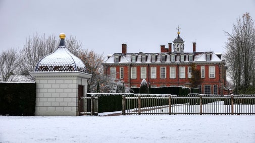 A photograph of the south wing of Hanbury Hall taken from the gardens with the property covered in snow